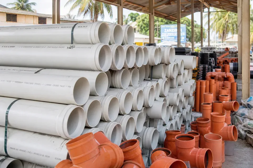 Close-up stacks of white PVC pipes and fittings
