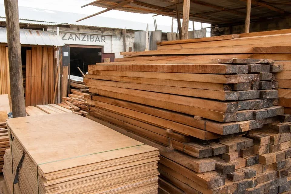 Timber planks stacked under warehouse cover