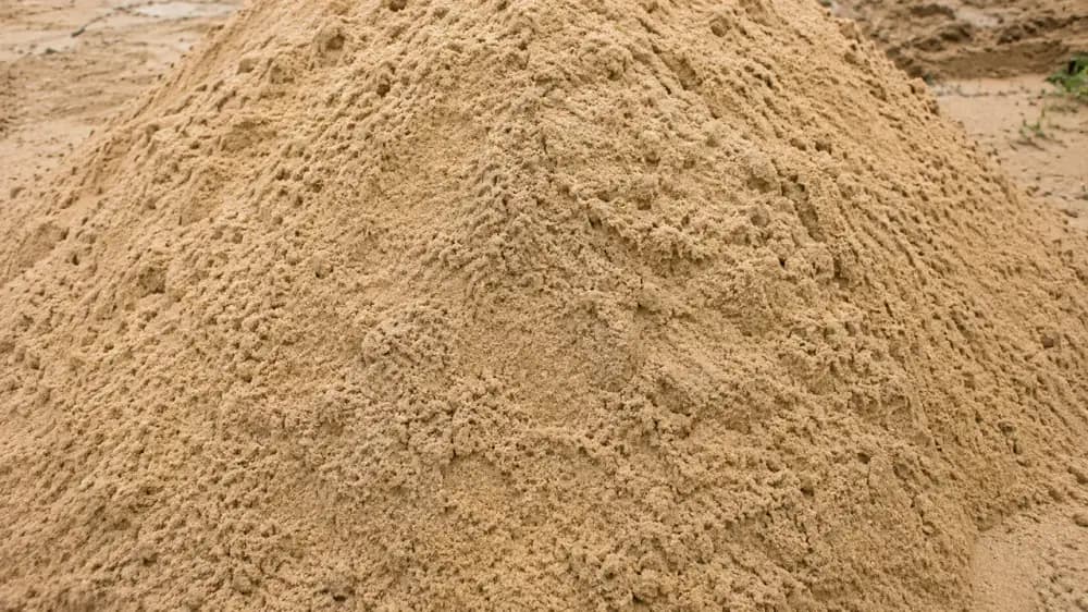 Large sand piles with loader at quarry site